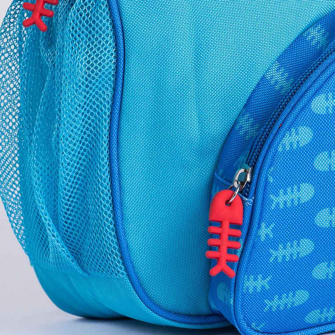 a close up of a blue bag with a red fish on it