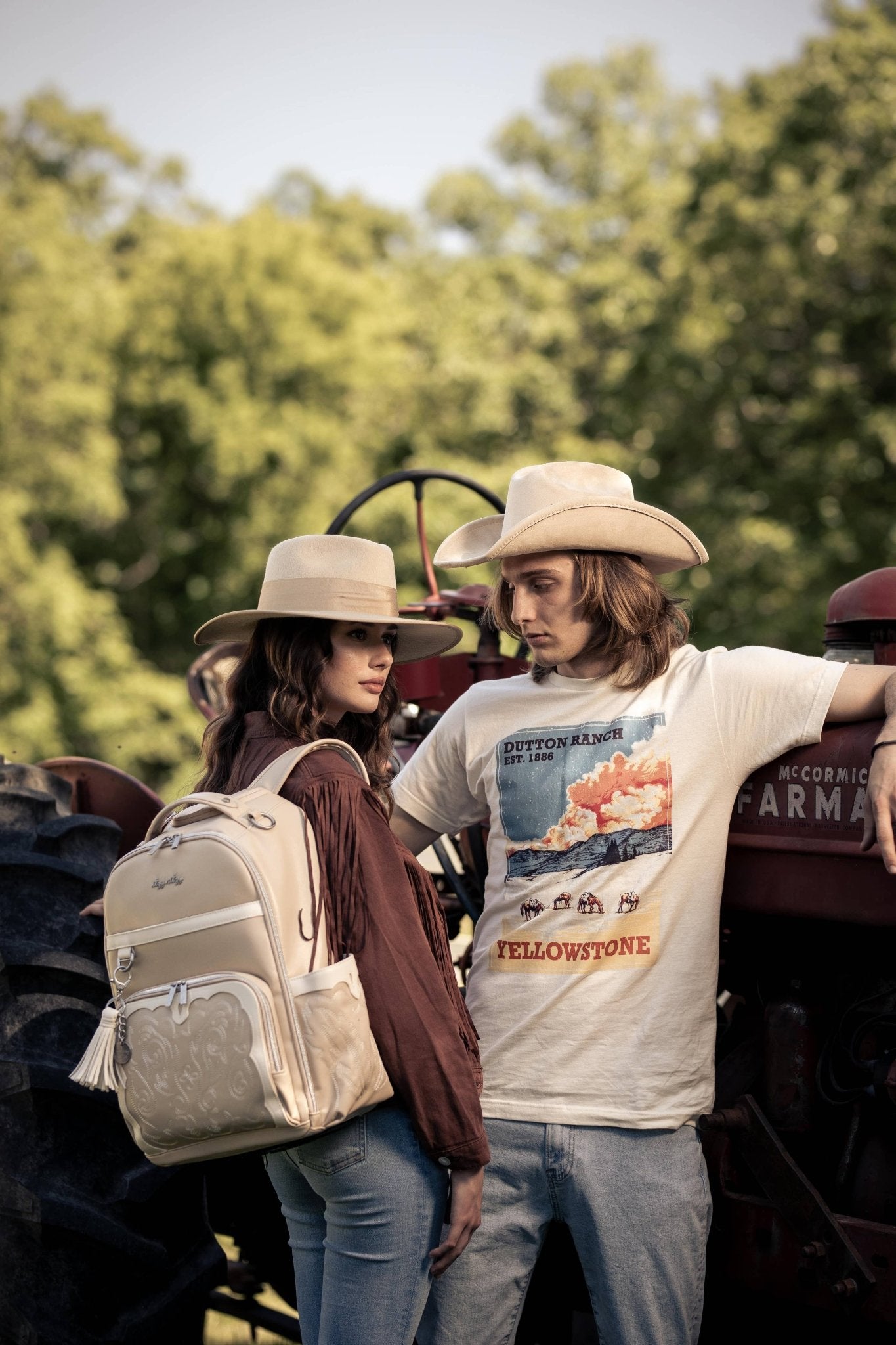 a man and a woman standing next to a tractor