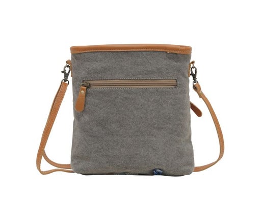 a gray bag with a brown strap