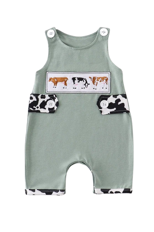 a baby romper with a cow print on it.