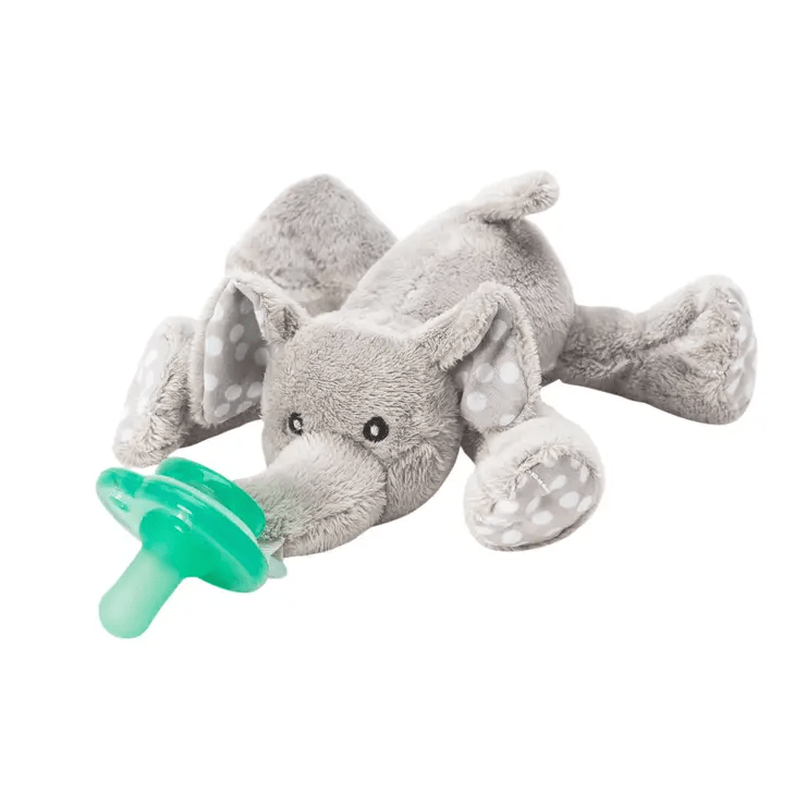 a stuffed elephant laying down with a pacifier on its mouth