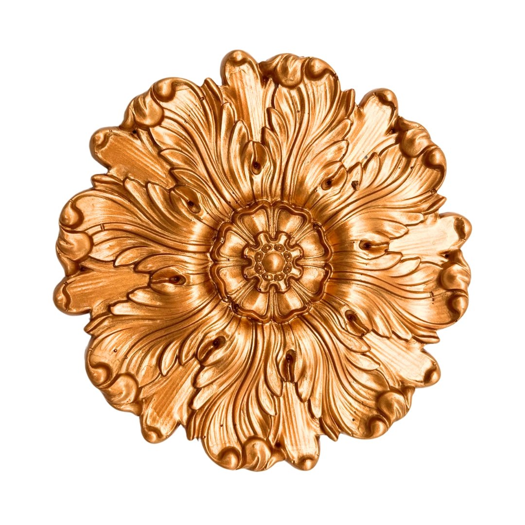 a golden flower shaped object on a white background