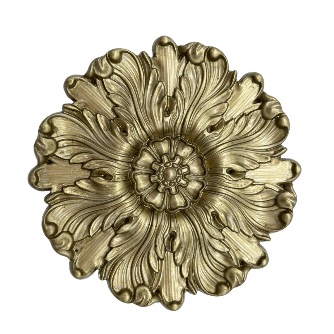 a gold flower shaped object on a white background