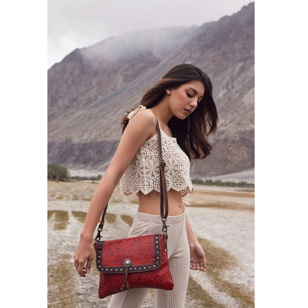 a woman carrying a red purse in the desert