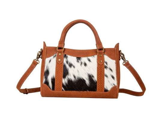 a handbag with a cow print pattern on it