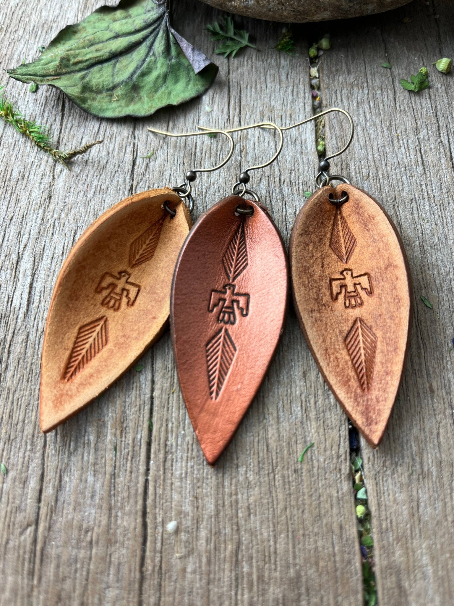 a pair of wooden earrings with arrows on them