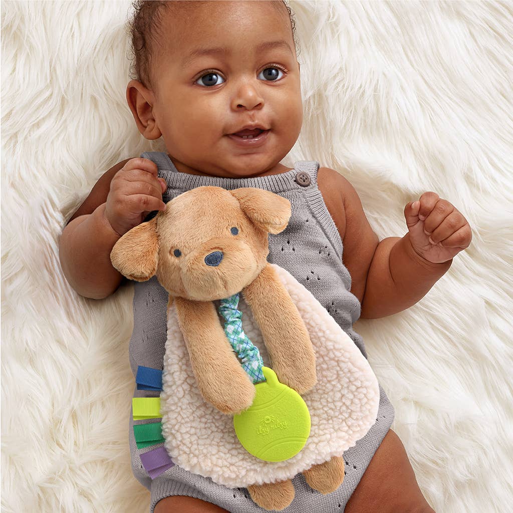 a baby is holding a stuffed animal on a blanket