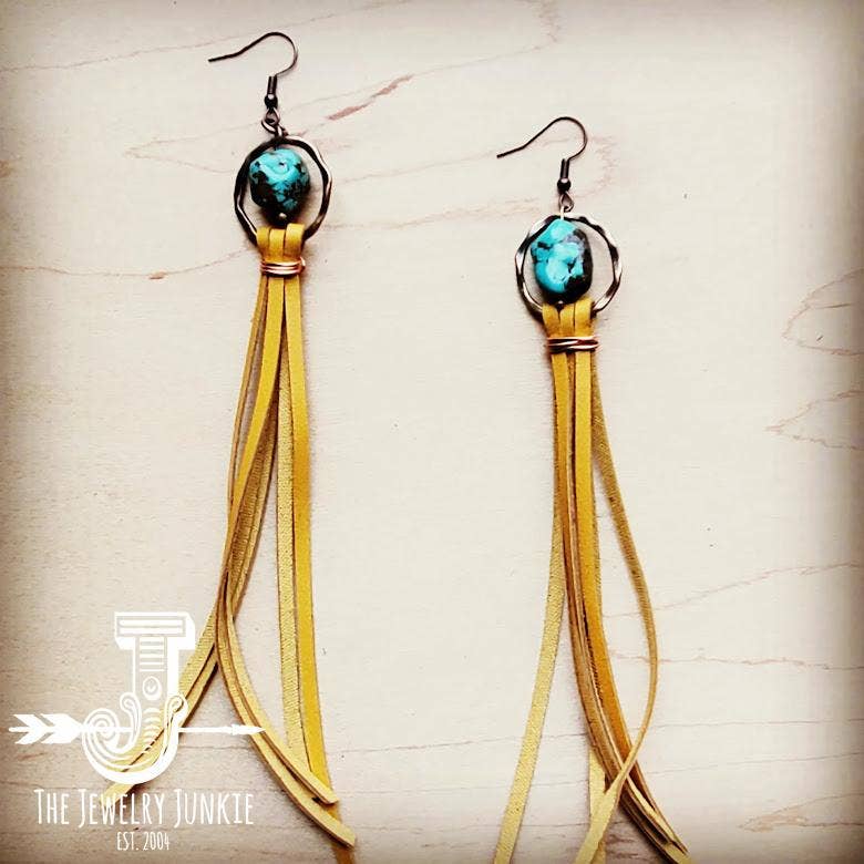 a pair of earrings with tassels and a turquoise stone