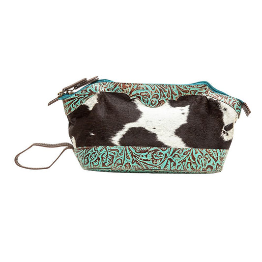 a black and white cow print bag on a white background