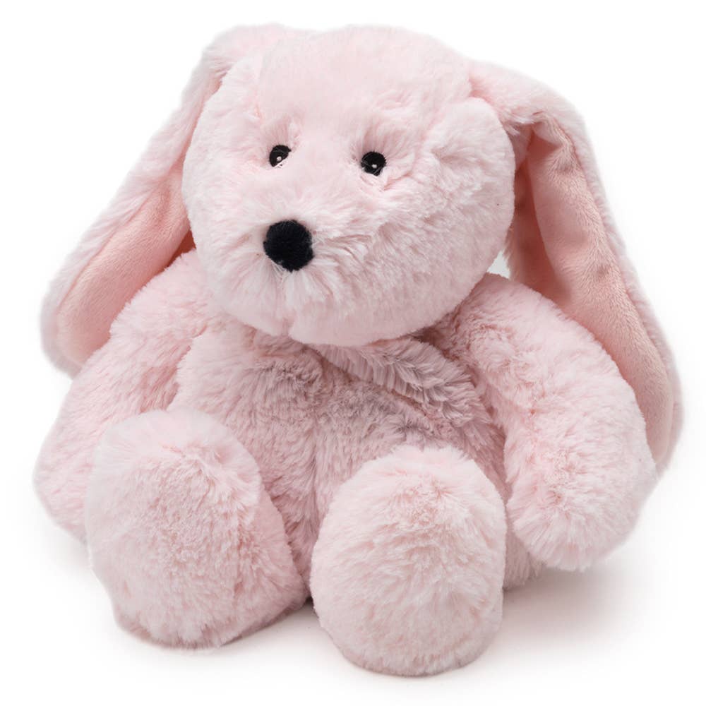 a pink stuffed rabbit sitting up against a white background