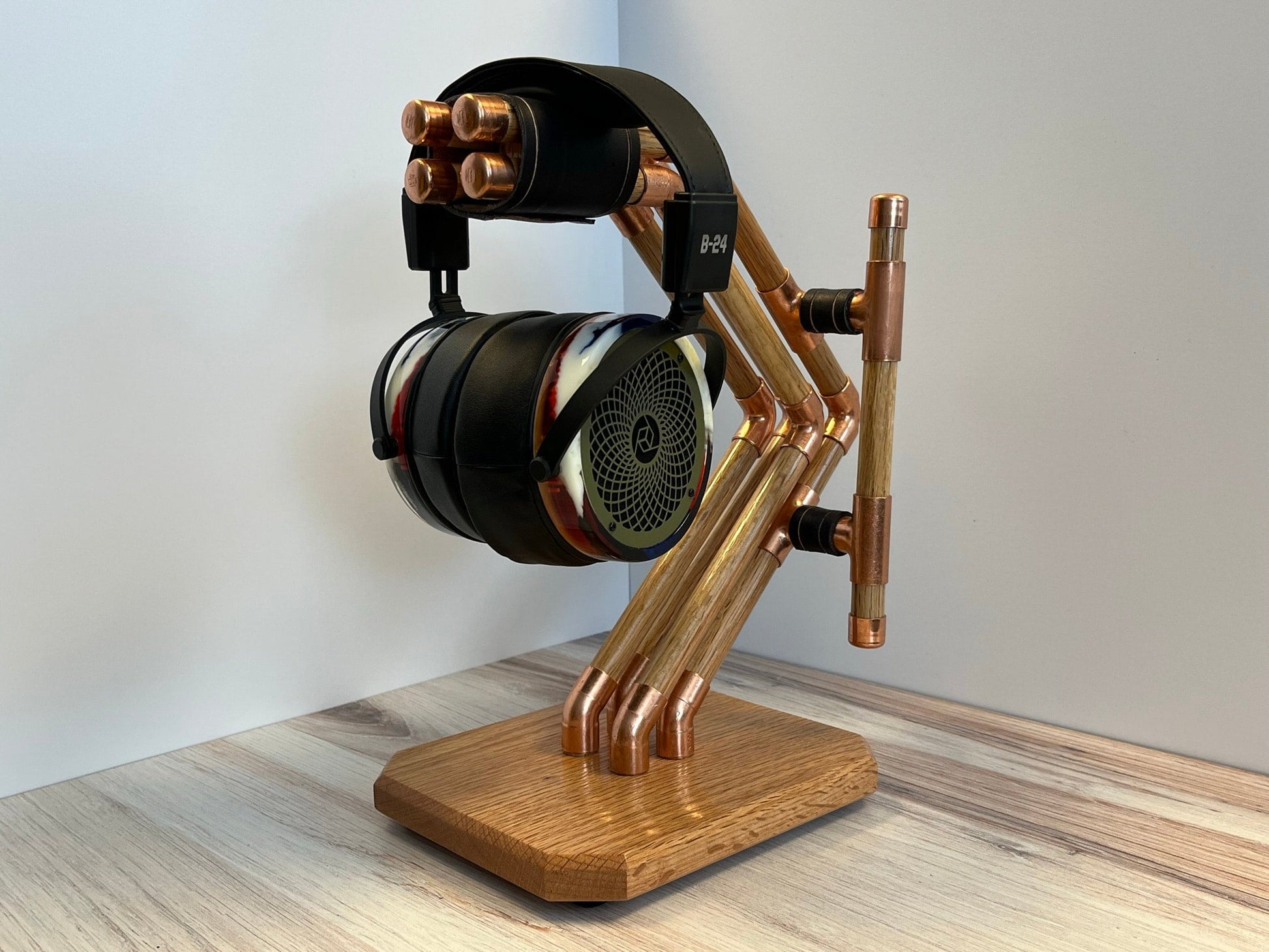 a headphone stand made out of copper pipes and wood and headphones on it