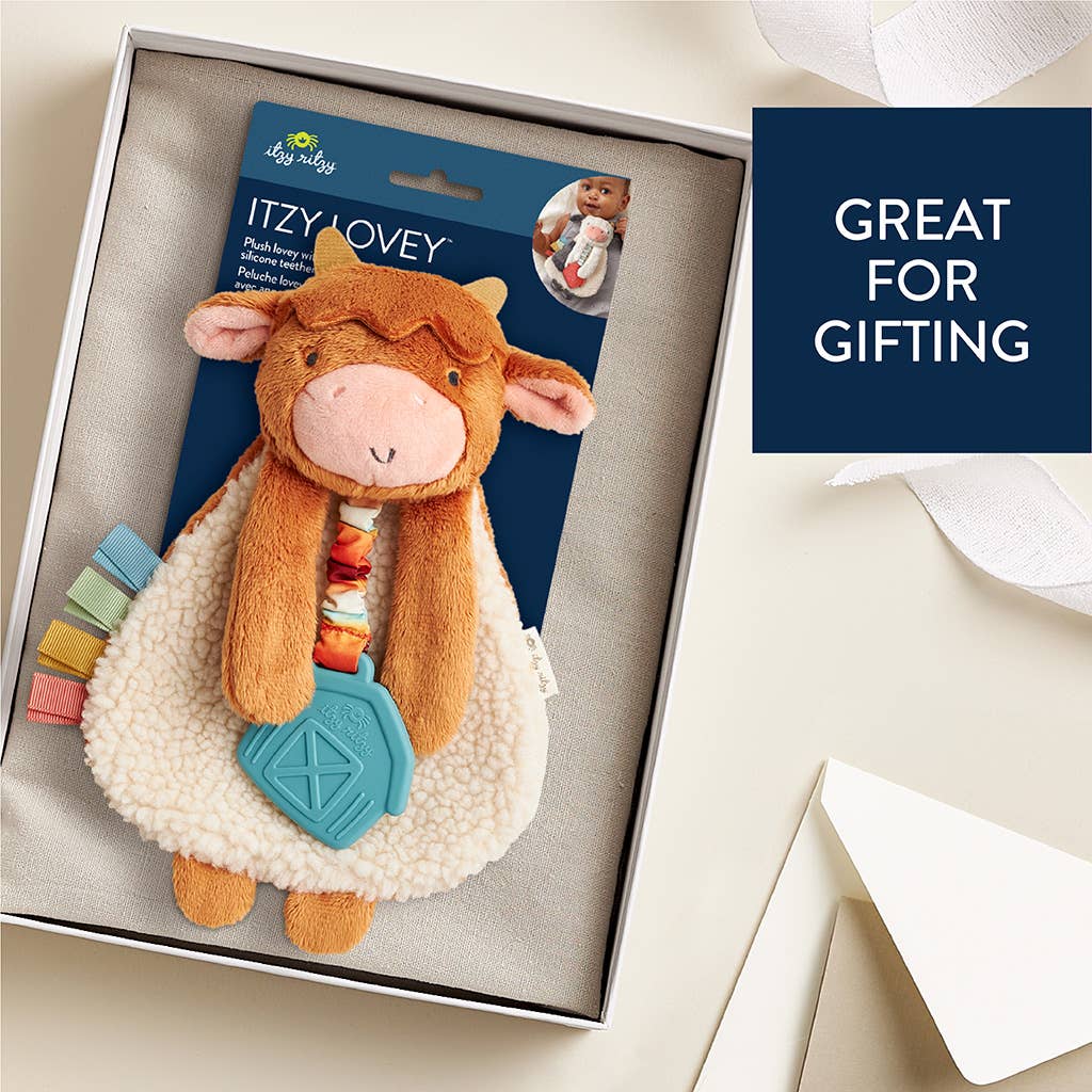 a stuffed cow in a gift box with a tag