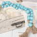 a blue beaded garland sitting on top of a wooden box