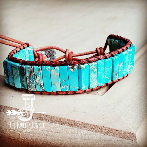 a turquoise and brown bracelet sitting on top of a wooden table