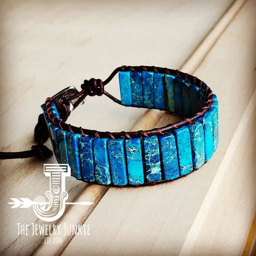 a blue bracelet with a leather cord on a wooden surface