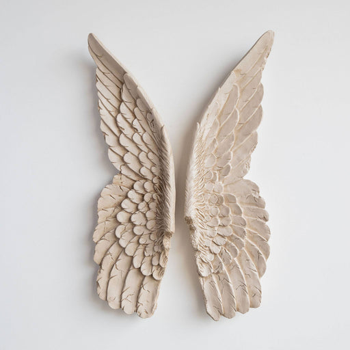 a pair of ivory distressed angel wings on a white background