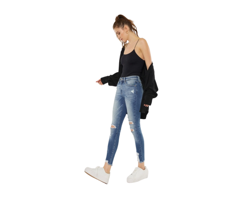 a woman in a black top and ripped jeans