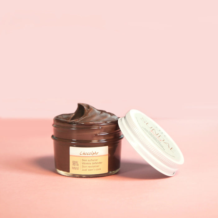 a jar of chocolate spread sitting on a pink surface