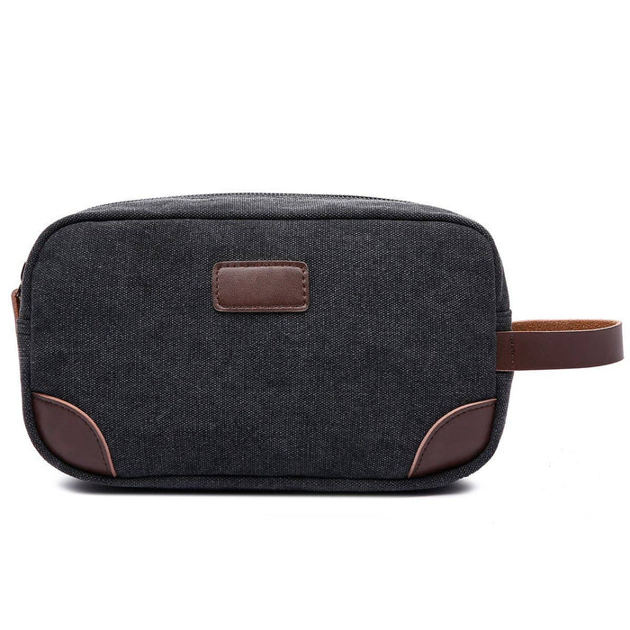 a dark gray canvas and brown leather dopp kit toiletries bag on a white background