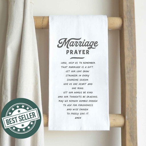 a white towel with a marriage prayer inscription on it hanging on a wooden ladder