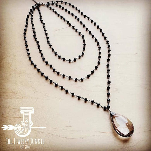 a black beaded necklace with a tear shaped pendant