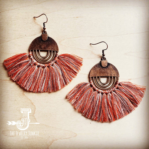 a pair of earrings with fringes hanging from them