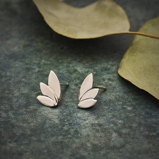 a pair of sterling silver three-petal earrings sitting on top of a table