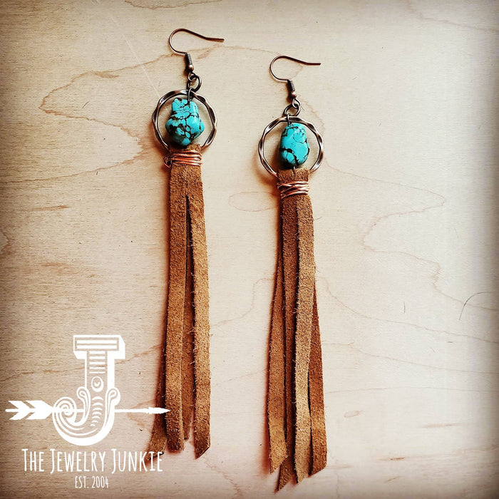 a pair of earrings with tassels and turquoise beads