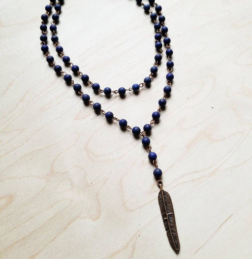 a blue beaded necklace with a feather charm