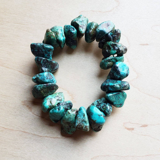 a bracelet made of turquoise stones on a table