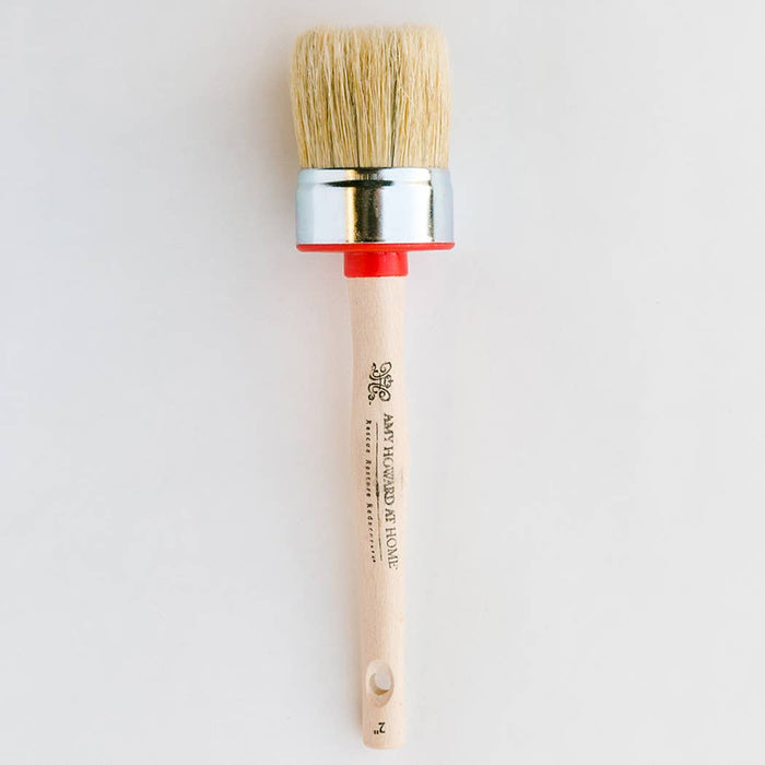 a round hog hair paint brush with a wooden handle on a white background