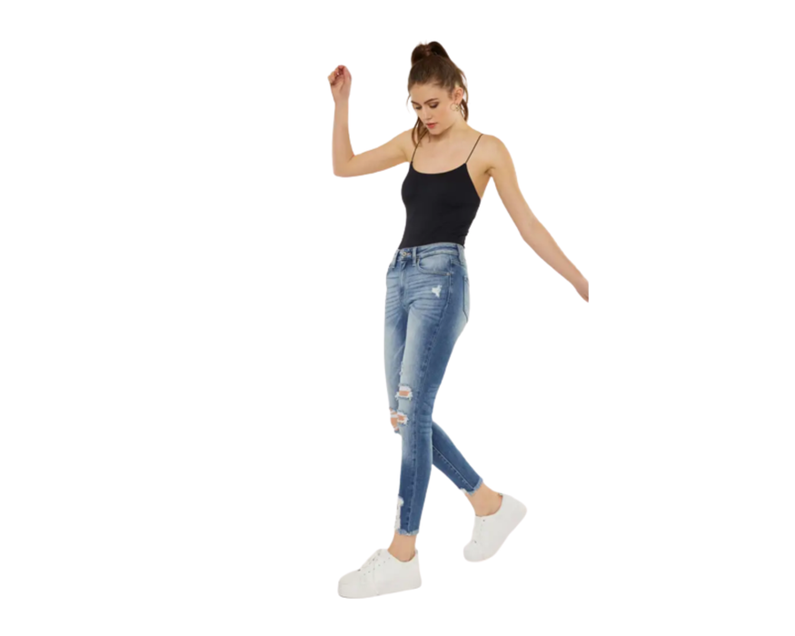 a woman in a black tank top and ripped jeans