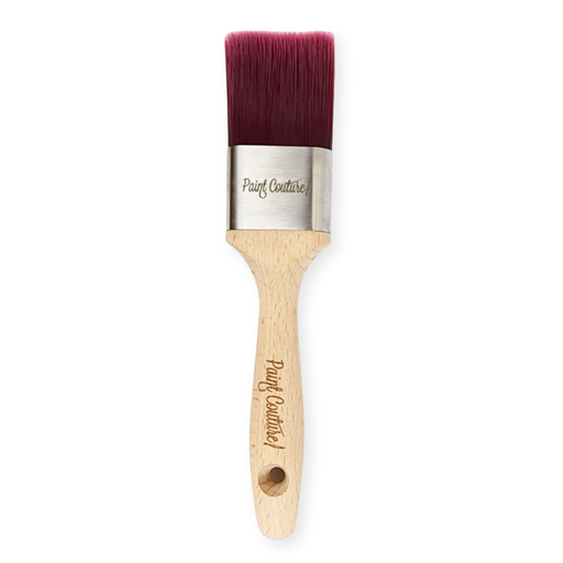 a Paint Couture paint brush with a wooden handle