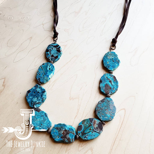 a necklace made of blue ocean agate on a wooden surface