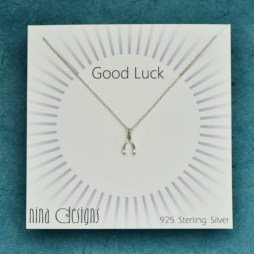 a card with a sterling silver wishbone necklace on it that says good luck
