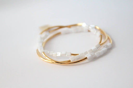 a stack of white and gold bracelets