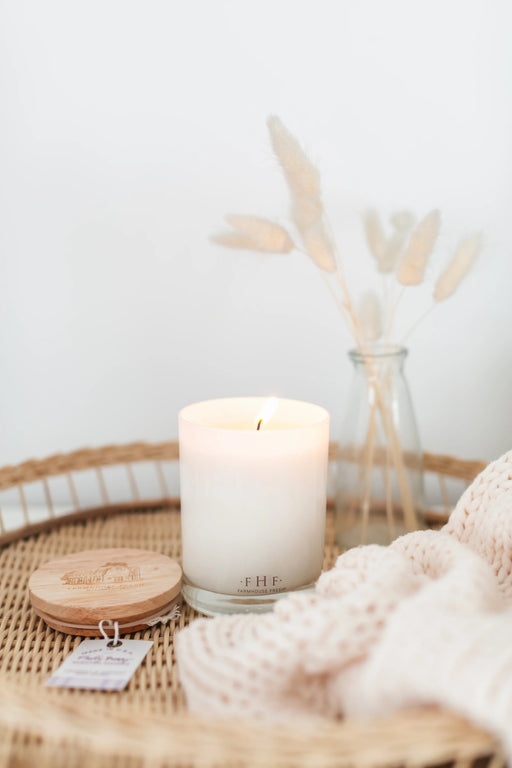 a white candle sitting on top of a wicker tray